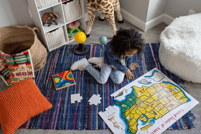 young girl looking at a map in her playroom