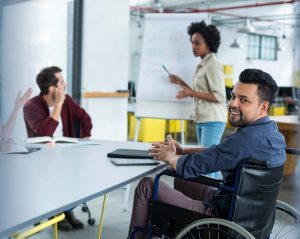 a man in a wheelchair at a business meeting