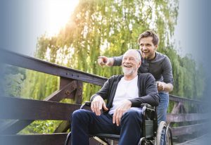 a senior man being pushed in a wheelchair by his attendant