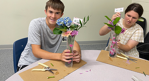 Two TSC students creating new flower arrangements for the non-profit TSC Is Spreading Petals